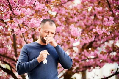 man sneezing outdoors